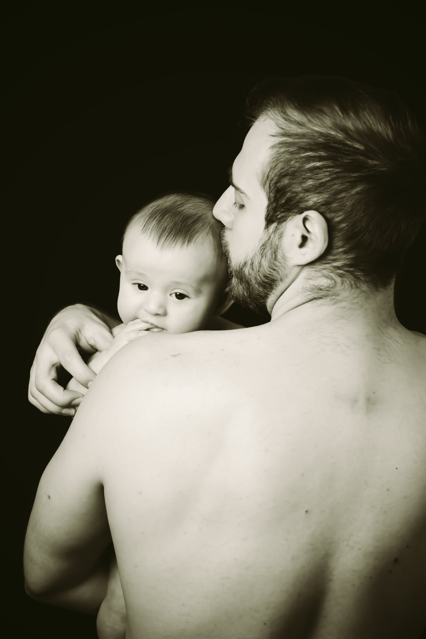 Dad holding newborn, B&W, tender.