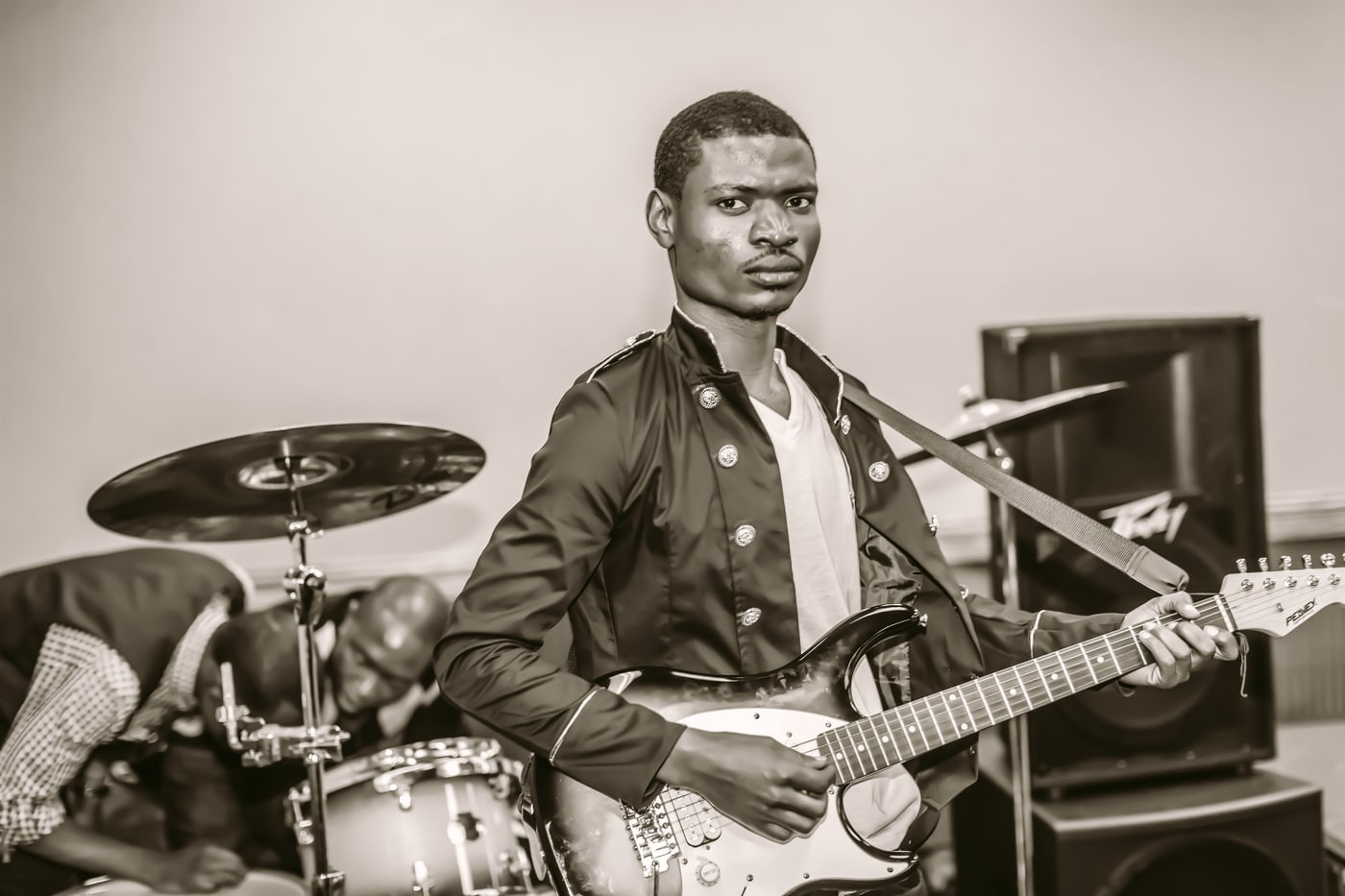 Black-and-white guitarist performance portrait.