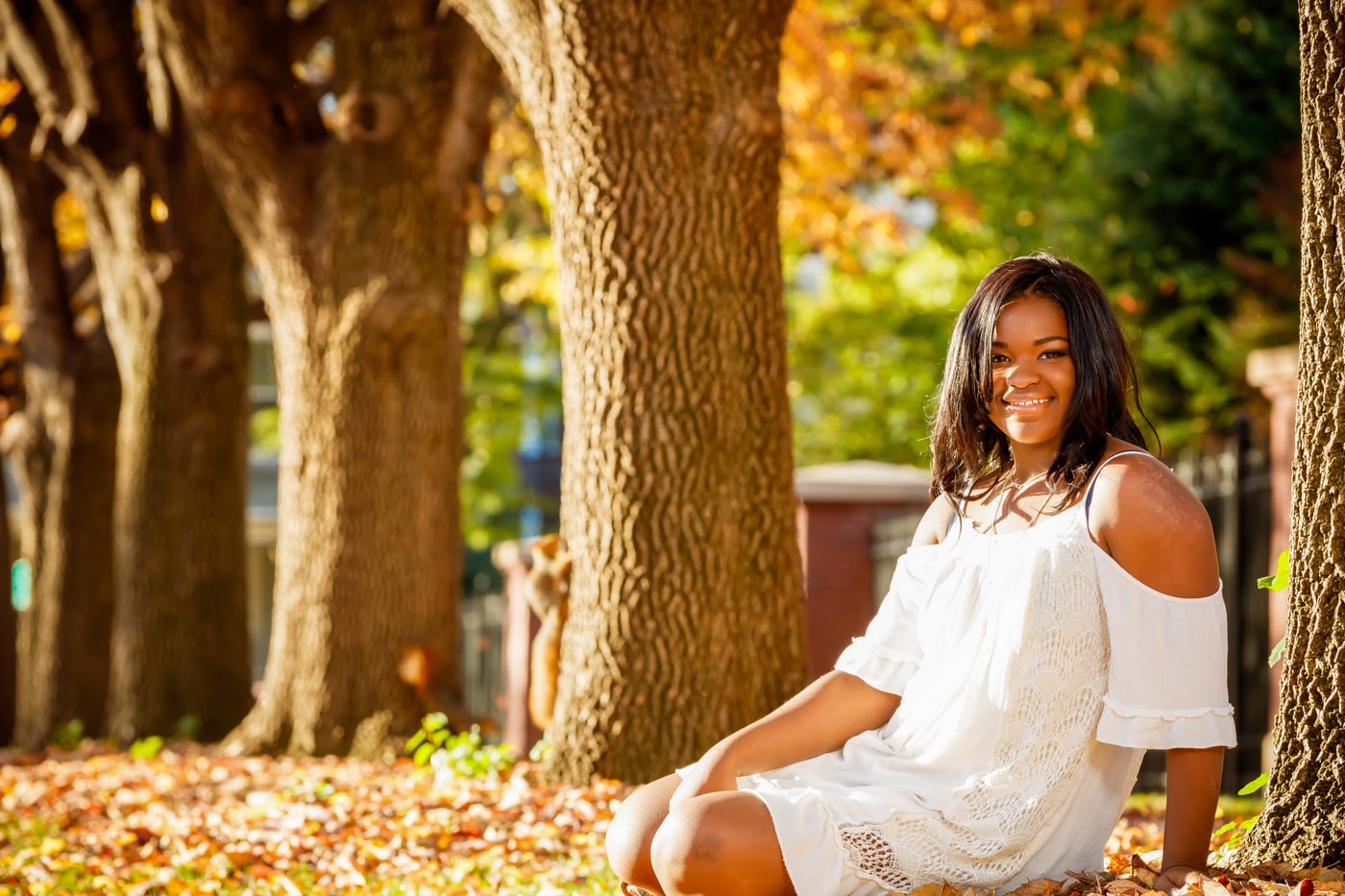 Bright outdoor senior portrait in white dress.