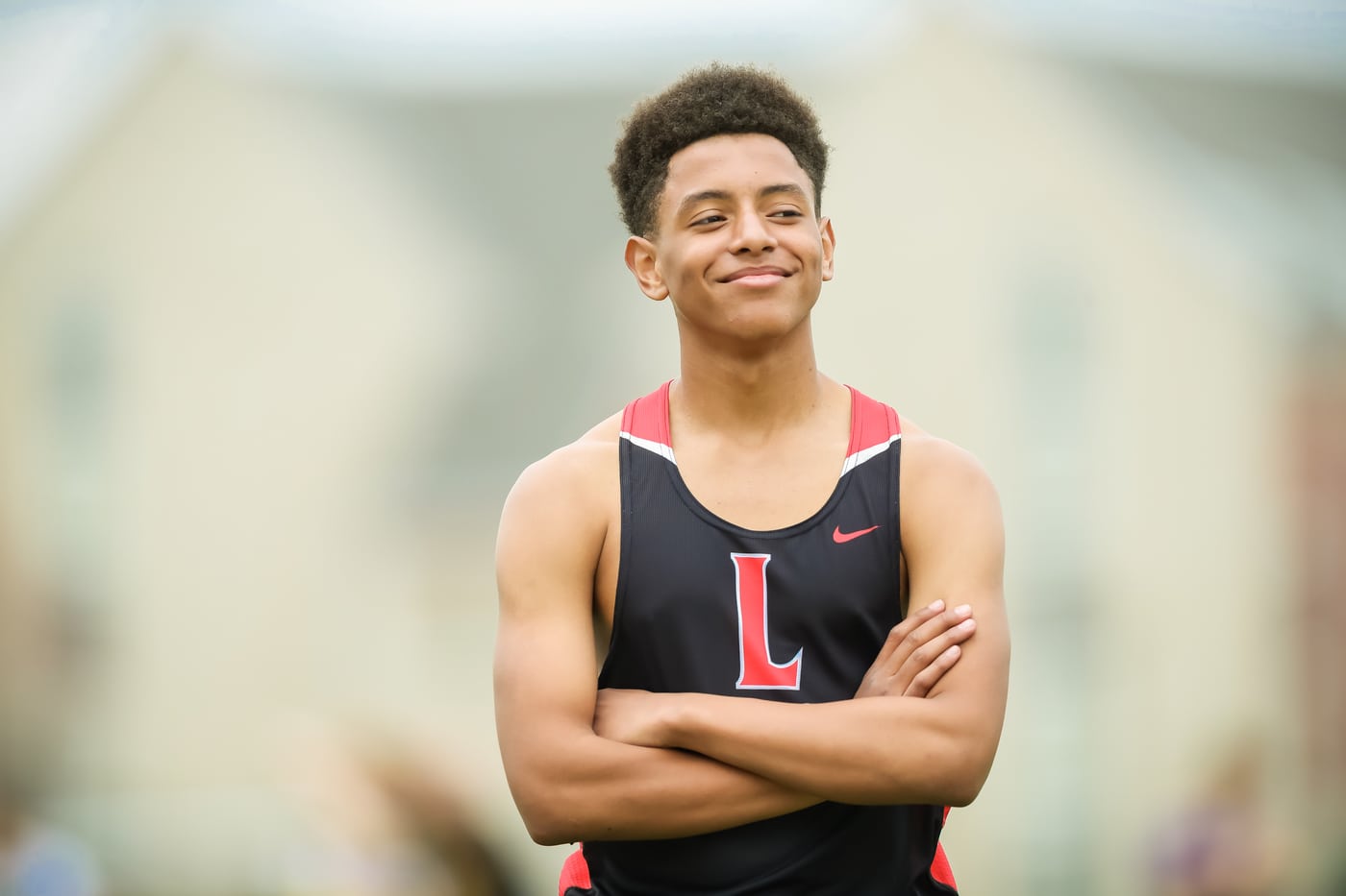 Track athlete L tank, arms crossed, athlete portrait.